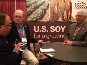 Bob Metz (middle), United Soybean Board (USB) Director, and Bob Henry (right), American Soybean Association (ASA) Vice President, talk to a representative from the Kansas Soybean Commission (left) about the importance of exports and sustainability.
