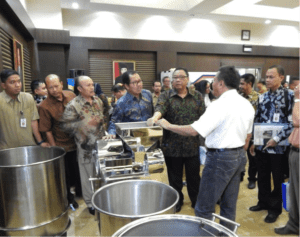 At the MoU signing: KOPTI Bogor District Head Mr. Sukhaeri (in white) explains the tempe processing technology with Mr. Anak Agung Puspayoya, Minister of Coopertives and MSMEs (green batik) and Head of the National Standards Body (blue batik)