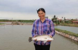 USSEC Cooperator, Ms.Ven of Thai Binh Province, shows a fish taken from a feed fed pond