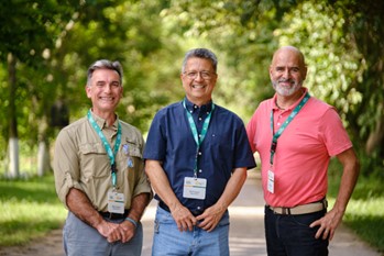Three agribusiness professionals posing together outside