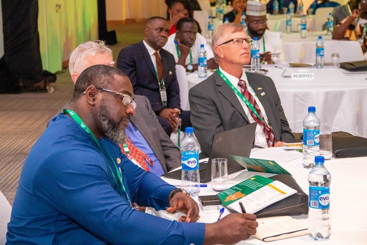 Three agribusiness professionals seated at a table listening to a presenter