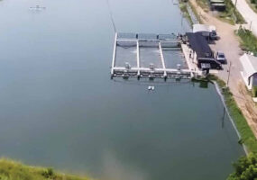 a man-made pond with a processing plant on the shore